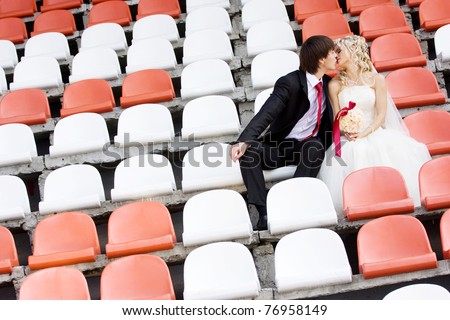 Bride and groom on the sport stadium seats