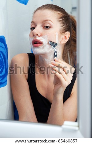 stock photo Funny girl shaving her face in bathroom