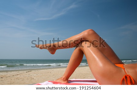 Picture with beach and tanned female legs