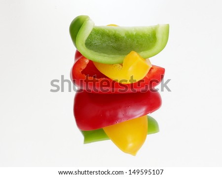 Three color pieces of peppers lying on the mirror