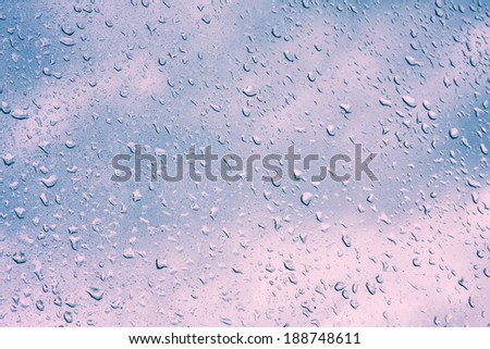 Water drops on window glass, blurred on the edges. Image processing with color filter effects