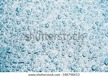Water drops on metal background with reflection blurred on the edges. Image processing with color filter effect