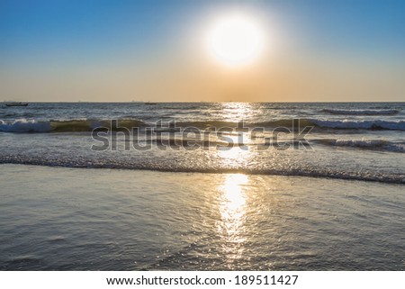 Scenic view from beach in Goa to beautiful sunrise above the Arabian sea. Sun reflection on sea surface
