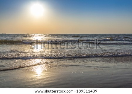Scenic view from beach in Goa to beautiful sunrise above the Arabian sea. Sun reflection on sea surface