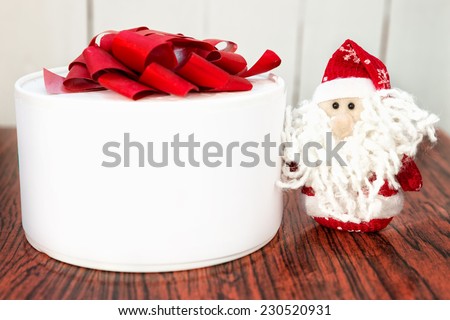 Christmas Santa Claus or Father Frost and white gift box or present on wooden background