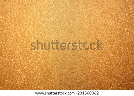 Abstract glittering golden or yellow dust or sand background with blur edges of image