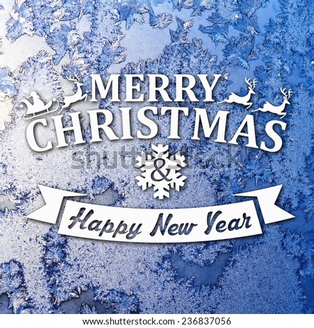 Merry Christmas and New Year greeting card on frozen winter blue colored background