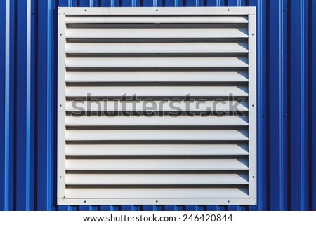 White window with jalousie in blue color metal siding wall
