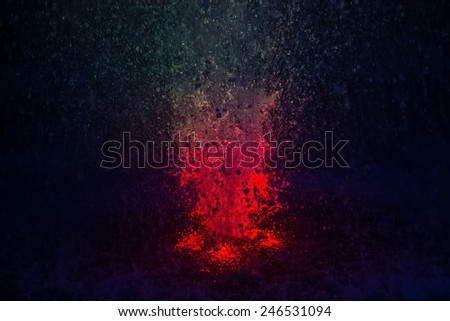 Abstract colorful fountain splashes red and blue color of water drops on a black background. motion blur