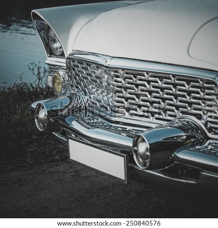 Old retro or vintage car or automobile front side with front lights or headlights and radiator grill. Processed by vintage or retro effect filter