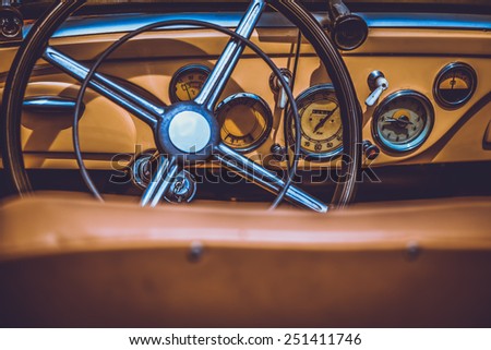 Steering wheel and dashboard in interior of old retro automobile. Processed by vintage or retro effect filter