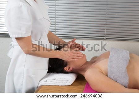 A woman spirit healer doing reiki treatment to a woman