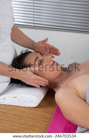 A woman spirit healer doing reiki treatment to a woman
