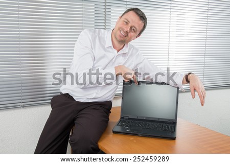 Portrait of confident nice and relaxing  man advertising laptop