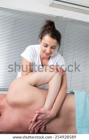 Male receiving massage by therapist in traditional thai position