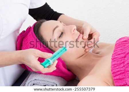 Cosmetic botox injection in the female face. Lips and cheek zone