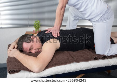 One man and woman performing back shiatsu massage