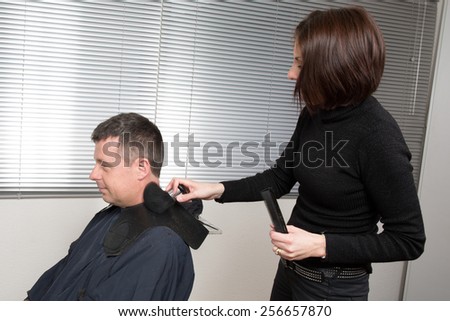 Hairdresser cuts hair with a electric razor