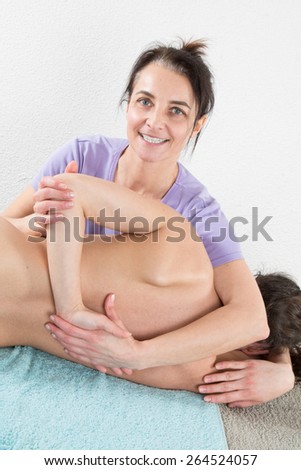 Woman therapist is doing massage on woman back in the spa salon