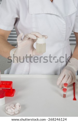 Chemical laboratory scene:  scientist observing the indicator