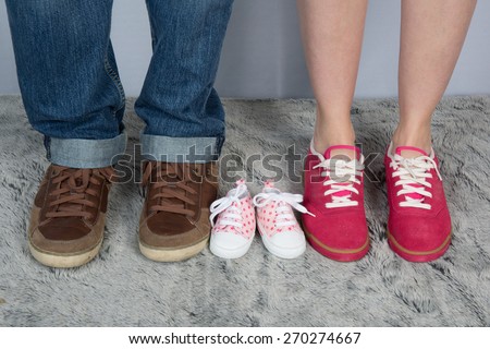 New parents with shoes and baby shoes next to them.
