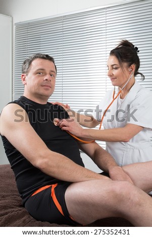 Doctor supervising the recovery of a sportsman patient