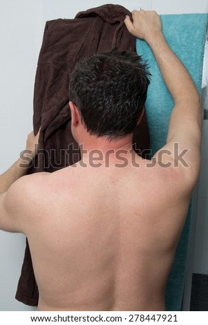 Rear view of a man goes out of his shower