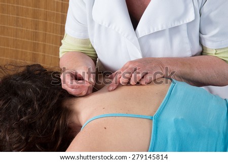 Bright caucasian woman receiving an acupuncture treatment in a health spa