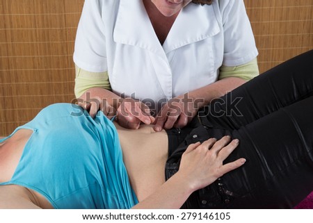 Acupuncture treatment - woman lying on back receiving acupuncture