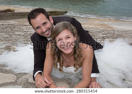 Newly wedding couple laying on the gound outside