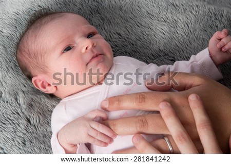 Close up of new born baby with parents hands on belly