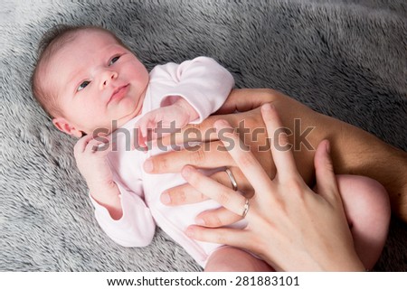 Close up of new born baby with parents hands on belly