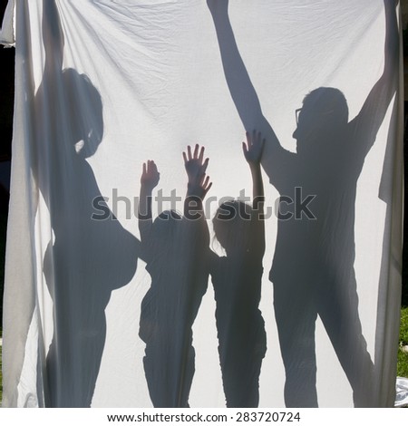 Shadows of a family behind a sheet -Symbol of a family