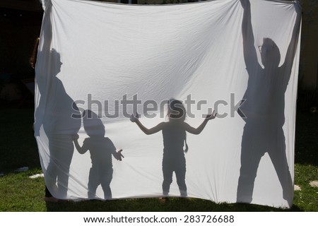 Shadows of a family behind a sheet -Symbol of a family