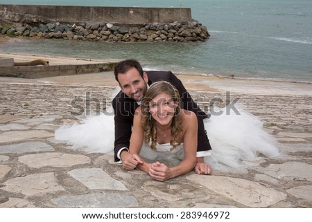 Newly wedding couple laying on the gound outside