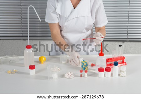 Chemical laboratory scene:  scientist observing the indicator
