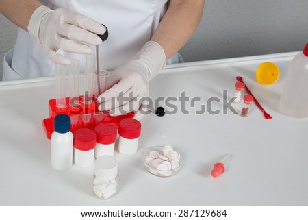 Laboratory assistant inserting laboratory glass bottle