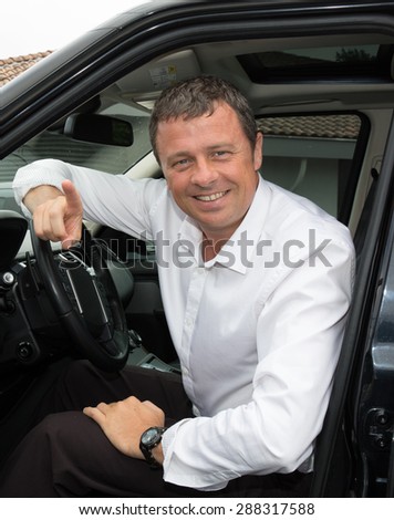 Attractive businessman gets into his car to go to work.