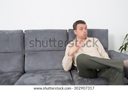 Portrait of a  relaxed man sitting on sofa in the house