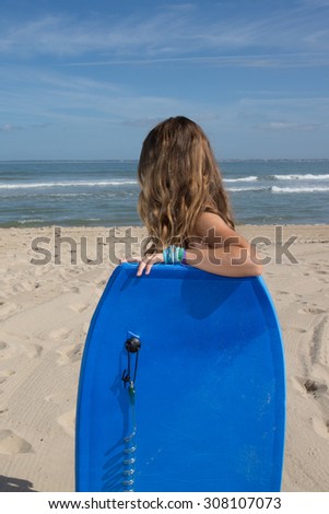 Young girl 10 years old with a body board at the beach
