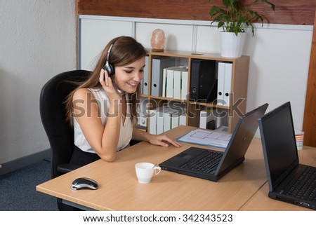 Picture of helpline operator with laptop computer and headphones