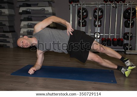 Fitness, sport, training, gym and lifestyle concept - smiling man doing push-ups in the gym or at home