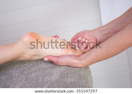Close-up of female hands doing foot massage at beauty center