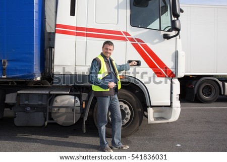 Logistics - proud driver with tablet computer, in front of trucks .
