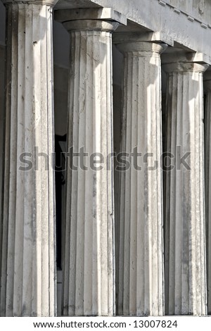 A row of greek pillars with capitals