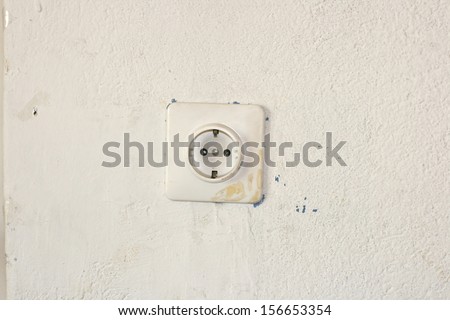 Old european socket plug on a dirty wall