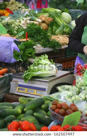 Fresh lettuce (Lactus sativa) on an old food retail scale, farmer\'s market, buying vegetables