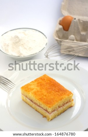 Home made victoria sponge or pound cake, a cake based on wheat flour, sugar, butter or oil and eggs mixed with baking powder with jam and whipped double cream