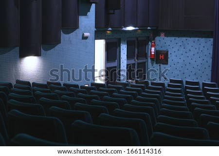 Exit doors in a dark blue movie theater (cinema), back to reality