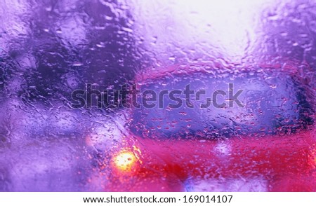 Road view through front car window with rain drops, drive carefully in heavy rain